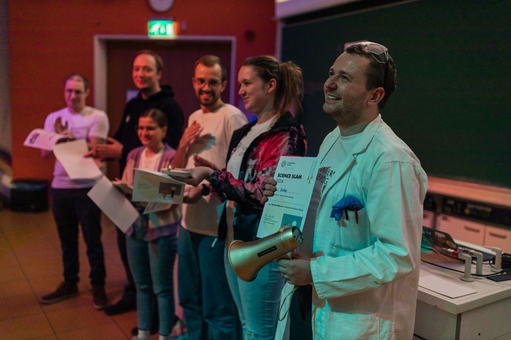 enlarge the image: All participants of the science slam standing on the stage